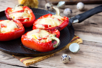 Red pepper stuffed with pasta and cheese on old wooden table