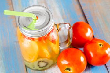 citrus fruits and kiwi, tomato in pitcher