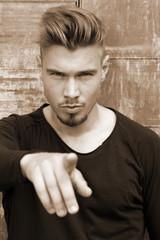 Attraktiver Junger Mann mit Undercut-Frisur zeigt auf etwas