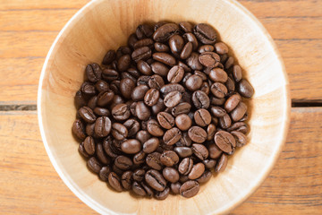 Roasted coffee beans in wooden bowl