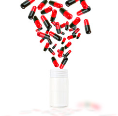 Fototapeta na wymiar Bright color pills flying away from open plastic bottle isolated on white