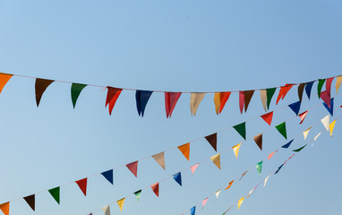 colorful festive bunting flags against a blue sky background