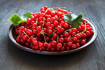Red currants on a clay plate