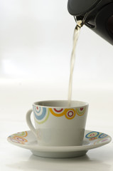 Tea pouring in cup from french press