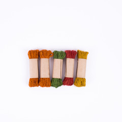 Rolls of rope in green, red, yellow, and orange color in white b