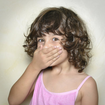 Ni&ntilde;a sorprendida y tap&aacute;ndose la boca