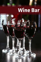 Glasses of red wine in bar on blurred background