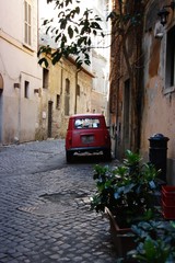 The narrow romantic Roman street and the old red car