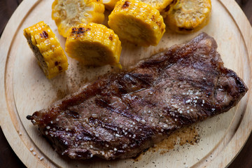Close-up of grilled striploin beef steak with roasted sweet corn