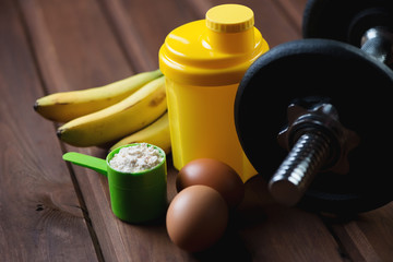 Shaker with a dumbbell, protein and protein food, close-up