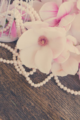 magnolia flowers with pearls on wooden table