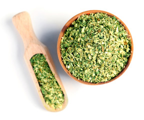 Dried parsley in wooden bowl, isolated on white