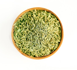 Cumin in wooden bowl, isolated on white