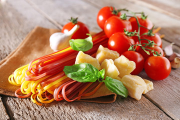 Pasta with cherry tomatoes and other ingredients on wooden table background