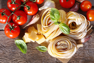 Pasta with cherry tomatoes and other ingredients on wooden table background