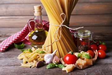 Pasta with cherry tomatoes and other ingredients on wooden background