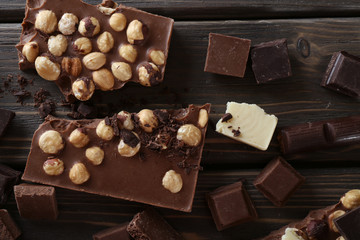 Set of chocolate with hazelnut on wooden table, top view