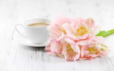 Fototapeta na wymiar Pink tulips with cup of coffee on wooden background
