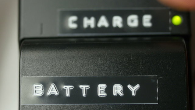 Camera battery charging on charger close-up
