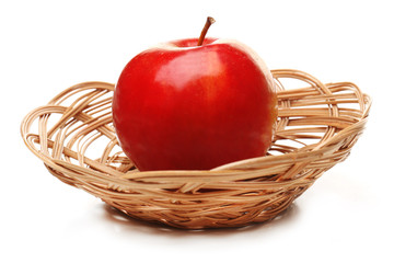 Apple in wicker basket isolated on white