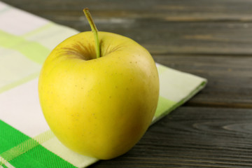Apple with napkin on wooden table, closeup