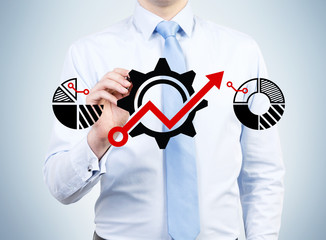 Businessman is drawing gears with red drawing arrow on the glass screen.