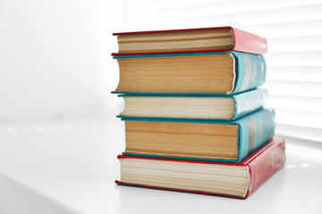 Books on white windowsill, close up