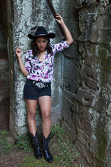 Thoughtful Hispanic woman outdoors with a black cowboy hat