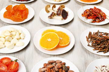 Different products on saucers on wooden table, closeup