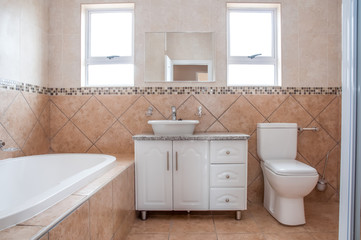 Fototapeta na wymiar New Bathroom with Bath, Basin, and Toilette