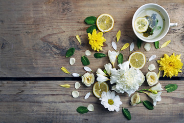 Cup of herbal tea with beautiful flowers, on wooden background