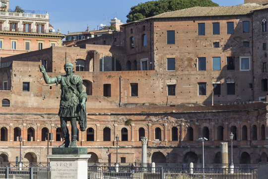 Statue of emperor Trajan with ruins of Trajan's forum in background, Rome, Italy