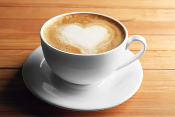 Fototapeta na wymiar Cup of coffee latte art on wooden background