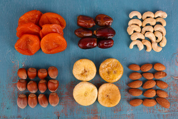 Dried fruits and nuts on color wooden background