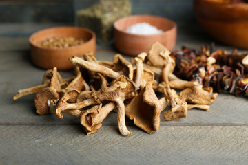 Dried mushrooms with spice on wooden background