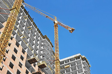  Crane and building construction site against blue sky