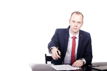 Businessman in red tie at the table reaches a pen 