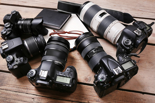 Still life with modern cameras on wooden table, closeup