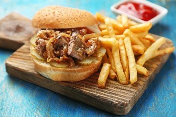 Tasty burger and french fries on wooden table background  Unhealthy food concept
