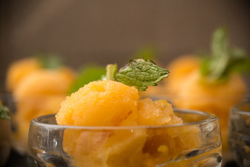 Apricot Sorbet topped with a mint leaf and served in a frosted glass.