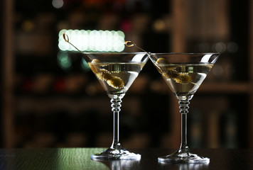 Glasses of cocktails on bar background