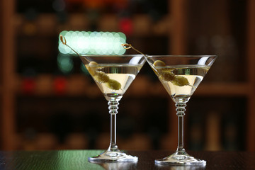 Glasses of cocktails on bar background