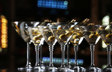 Glasses of cocktails on bar background