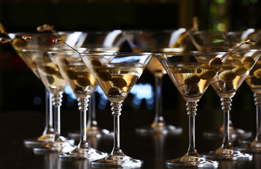 Glasses of cocktails on bar background