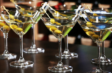 Glasses of cocktails on bar background
