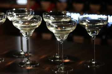 Glasses of cocktails on bar background