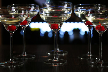 Glasses of cocktails on bar background