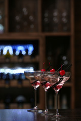 Glasses of cocktails on bar background