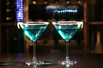 Glasses of cocktails on bar background