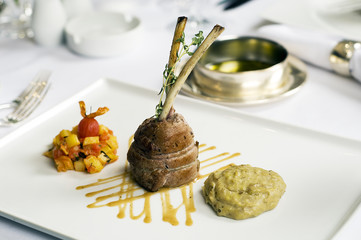 Fine restaurant dinner table place setting: napkin, wineglass, plate, beef and wine